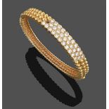 A Diamond Bangle, three rows of round brilliant cut diamonds in yellow claw and rubbed over