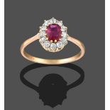 A Ruby and Diamond Cluster Ring, the oval cut ruby within a border of old cut diamonds, in yellow
