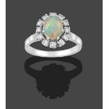 An Opal and Diamond Cluster Ring, the oval cabochon opal within a border of round brilliant cut