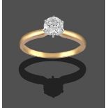 A Diamond Solitaire Ring, the round brilliant cut diamond in a white claw setting, on a yellow