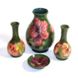 Four Walter Moorcroft hibiscus vases and dish on a green ground