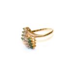 An abstract emerald and diamond ring, stamped '585', finger size S. Gross weight 3.5 grams.