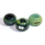 Three large Mdina glass paperweights, in blue, green and yellow, two signed Mdina, 12cm diameter