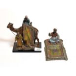 After Bergmann: An Orientalist style figural table lighter of a camel and rider together with a