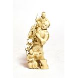 A Japanese carved ivory figure, late 19th century, carved as a figure supporting a child and with