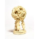 An early 20th century ivory puzzle ball raised on elephant stand