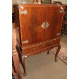 A mid 20th century mahogany cocktail cabinet on claw and ball feet