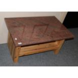 A pine coffee table with a marble top