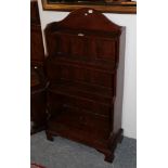 A reproduction oak waterfall bookcase, the base with a single drawer, 63cm wide by 30cm deep by