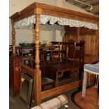 A reproduction carved pine king size full tester bed, panelled headboard and canopy, 224cm high by