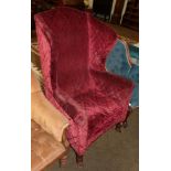 A 19th century ruby red upholstered wingback armchair