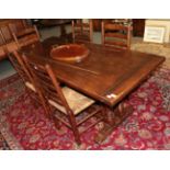 A Titchmarsh & Goodwin style oak refectory dining table with seven rush seated chairs, including two