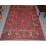 Donegal rug, the scarlet field with Ushak medallions enclosed by flower head borders, 231cm by