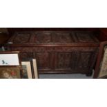 A late 17th century oak panelled coffer, hinged lid, bearing date, carved detail and bracket feet