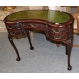 A leather inset mahogany reniform writing table