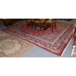 Mashad carpet, the light red field of vines around a medallion, framed by spandrels and indigo