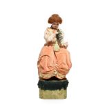 A Seated Doll Musical Automaton, with fan, beadwork headdress, necklace, dress with peach hued