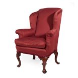 A George II Style Wing-Back Armchair, recovered in red fabric, with rounded arms and a squab cushion