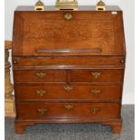 An Early 18th Century Oak Bureau, the fall enclosing a sliding well, pigeon holes and small drawers,