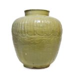 A Chinese Celadon Glazed Jar, in Song style, of ovoid form, carved with gadroons and waves, 36cm