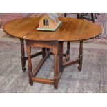 An Early 18th Century Oak Gateleg Table, with two drop leaves to form an oval, on baluster legs with