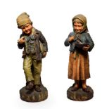 A Pair of Austrian Painted Terracotta Figures of Urchins, circa 1900, she with a bowl of food and