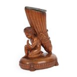 A Carved Walnut Cornucopia Vase, in Empire style, modelled as a kneeling putto supporting the ribbon