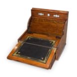 A Late Victorian Oak Travelling Writing Desk, the shaped hinged top over perpetual calendar with