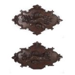 A Pair of Carved and Stained Limewood Wall Appliques, late 19th century, worked in relief with