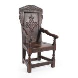 A Joined Oak Wainscot Armchair, dated 1687 EG, the carved top rail above a scroll and lozenge carved