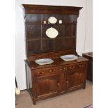 A Mid 18th Century Oak Dresser, the rack with a bold cornice above five cup hooks with two shelves