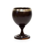 A White Metal Mounted Lignum Vitae Pedestal Cup, early 19th century, of ovoid form, the rim mount