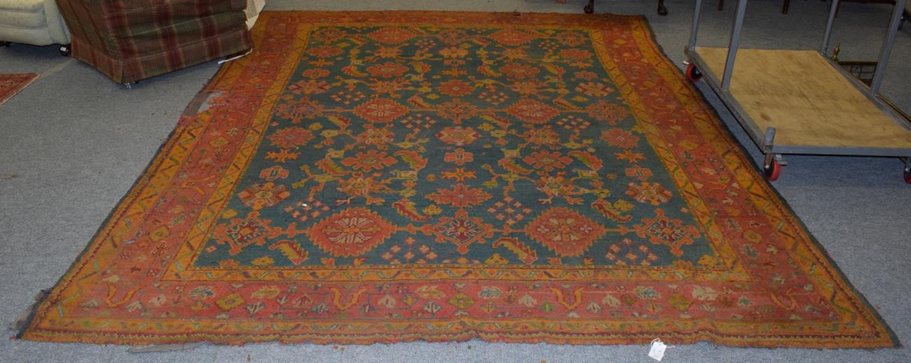 Ushak carpet, the field of serrated ruler of leaves enclosed by stylised vine borders, 358cm by