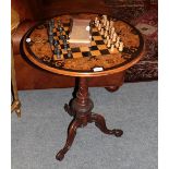 A mahogany inlaid tripod games table, together with a carved wooden chess set, with box