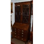 A George III oak bureau bookcase, associated top, twin astragal glazed doors above fall flap, fitted