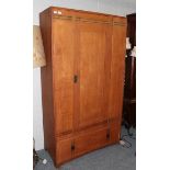 An Arts & Crafts Oak Wardrobe, with ebony stringing, the single door above a drawer, 107.5cm wide,