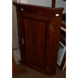 A George III oak and mahogany wall hanging corner cupboard, moulded cornice above single crossbanded