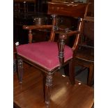 A mid-19th century mahogany open arm chair, the crest rail above a carved stretcher, the out swept