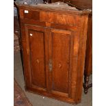 A George III oak wall hanging corner cupboard, twin crossbanded doors with inlaid shell detail,