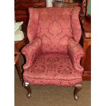 A Georgian style wingback armchair, red foliate upholstery