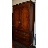 A George III mahogany linen press, moulded cornice above twin oval crossbanded panel doors, the base