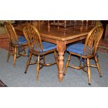 A pine kitchen table, together with a set of four spindle back chairs
