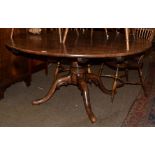 A Georgian style elm tilt top breakfast table, turned central column and four out swept legs, by