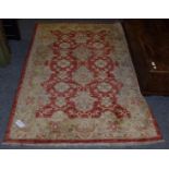 Afgan Rug, the strawberry field of stylised flower heads framed by floral borders, 178cm by 129cm