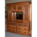 A large early 20th century oak mirrored back bookcase, three glazed cabinets above base with six