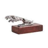A Chrome Car Mascot as a Leaping Jaguar, mounted on a stained wood rectangular base, 13cm long