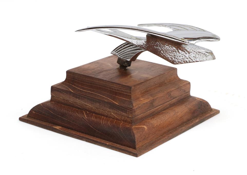 An Art Deco Style Chrome Plated Car Mascot as a Stylised Flying Swift, mounted on a graduated oak