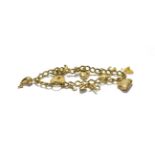 A charm bracelet with a 9 carat gold padlock clasp hung with various charms including a boot, a