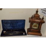 A walnut striking mantel clock with German movement; together with a horn handled carving set (a.