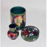 Three pieces of Walter Moorcroft pottery, comprising a leaf and berry vase, 18.5cm high; a orchid